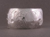 photo of Hand carved sterling totem bracelet showing the bear and the salmon 